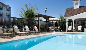 Sonesta Simply Suites Seattle Renton’s outdoor pool is fenced off and has both sun loungers and chairs by the side.