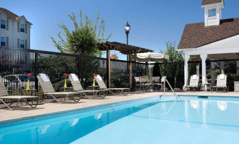 Sonesta Simply Suites Seattle Renton’s outdoor pool is fenced off and has both sun loungers and chairs by the side.