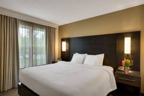 Double bed guest room in Sonesta ES Suites Parsippany Morris Plains, with bedside lighting and a large window.