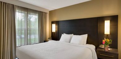 Double bed guest room in Sonesta ES Suites Parsippany Morris Plains, with bedside lighting and a large window.