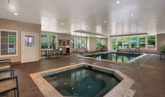 Sonesta ES Suites Parsippany Morris Plains’ indoor pool has a hot tub nearby, chairs and sun loungers nearby, and large windows.