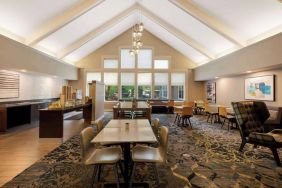 The hotel’s breakfast area is spacious and has large windows, with tables varying from two seats to eight, and art on the wall.