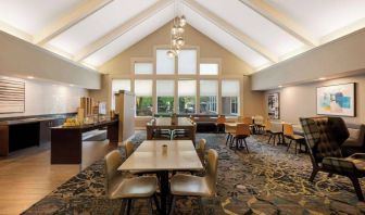 The hotel’s breakfast area is spacious and has large windows, with tables varying from two seats to eight, and art on the wall.