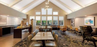 The hotel’s breakfast area is spacious and has large windows, with tables varying from two seats to eight, and art on the wall.