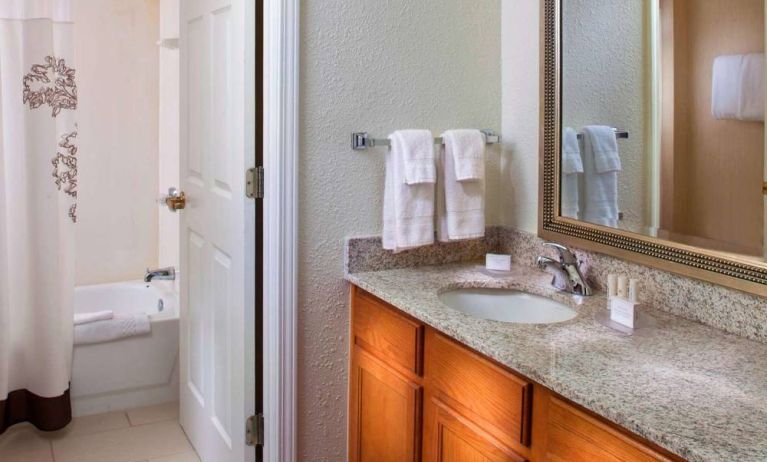 Sonesta ES Suites Birmingham Homewood guest bathroom, with sink, mirror, and bath (including shower).