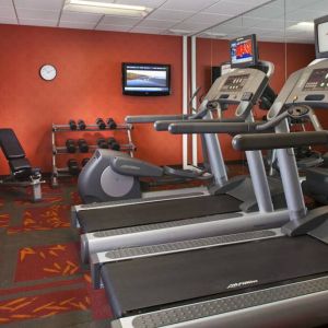 Sonesta ES Suites Birmingham Homewood’s fitness center features treadmills, an elliptical, bench, and rows of free weights, plus a TV.