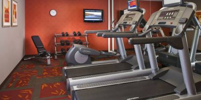 Sonesta ES Suites Birmingham Homewood’s fitness center features treadmills, an elliptical, bench, and rows of free weights, plus a TV.