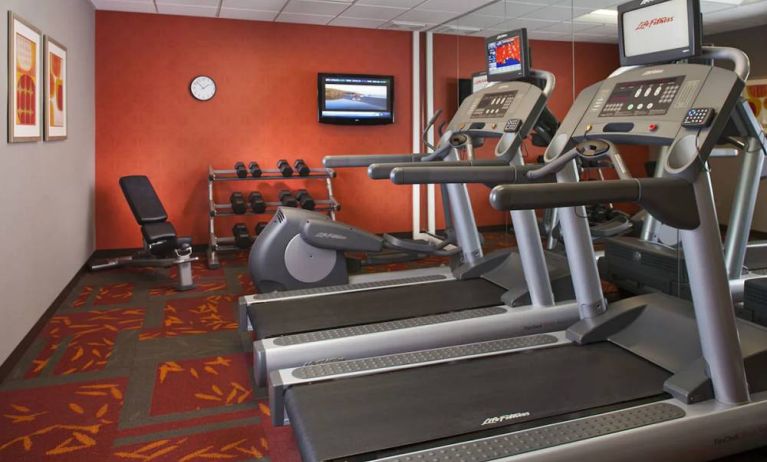 Sonesta ES Suites Birmingham Homewood’s fitness center features treadmills, an elliptical, bench, and rows of free weights, plus a TV.