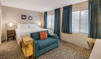 Sonesta ES Suites Andover Boston double bed guest room, including sofa, coffee table, and two windows.