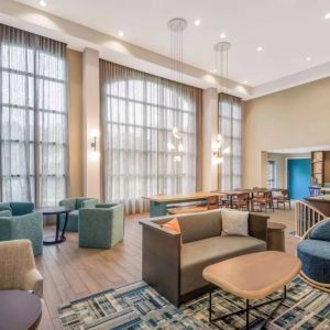 The hotel’s lobby lounge has a high ceiling and full-length windows, comfortable seating including armchairs and sofas, and numerous coffee tables.