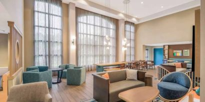 The hotel’s lobby lounge has a high ceiling and full-length windows, comfortable seating including armchairs and sofas, and numerous coffee tables.