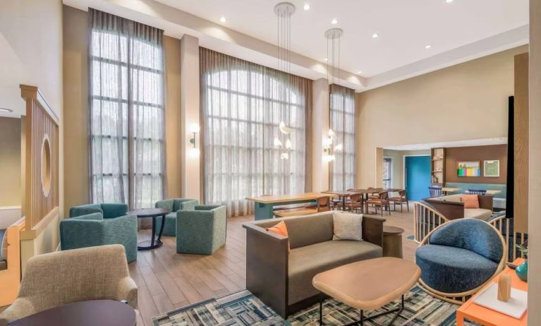 The hotel’s lobby lounge has a high ceiling and full-length windows, comfortable seating including armchairs and sofas, and numerous coffee tables.