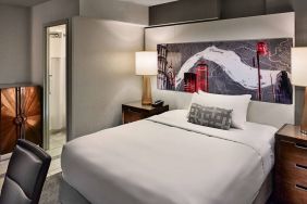 Sonesta Philadelphia Rittenhouse Square double bed guest room, featuring art on the wall, chair, and ensuite bathroom.