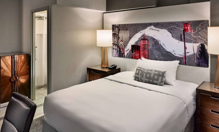 Sonesta Philadelphia Rittenhouse Square double bed guest room, featuring art on the wall, chair, and ensuite bathroom.