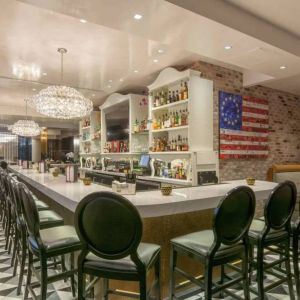 The hotel restaurant has tall stool seating at the bar, an extensive range of beverages, and an artistic 13 star Betsy Ross variant of the Stars and Stripes on the wall.