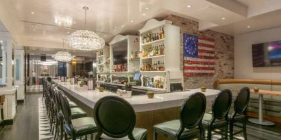 The hotel restaurant has tall stool seating at the bar, an extensive range of beverages, and an artistic 13 star Betsy Ross variant of the Stars and Stripes on the wall.