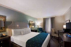 Double bed guest room in Royal Sonesta New Orleans, featuring television, armchair, and a workspace desk and chair.