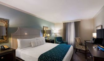 Double bed guest room in Royal Sonesta New Orleans, featuring television, armchair, and a workspace desk and chair.