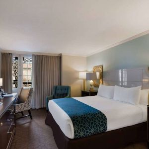 Royal Sonesta New Orleans double bed guest room, furnished with armchairs, desk, and a television.