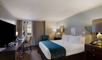 Royal Sonesta New Orleans double bed guest room, furnished with armchairs, desk, and a television.