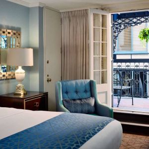 Double bed guest room in Royal Sonesta New Orleans, including armchair and a balcony.