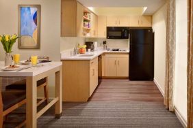 Sonesta ES Suites Atlanta - Perimeter Center North guest room kitchen, featuring fridge-freezer, microwave, hob, and oven.