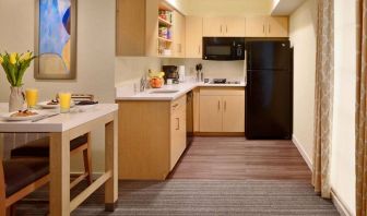 Sonesta ES Suites Atlanta - Perimeter Center North guest room kitchen, featuring fridge-freezer, microwave, hob, and oven.