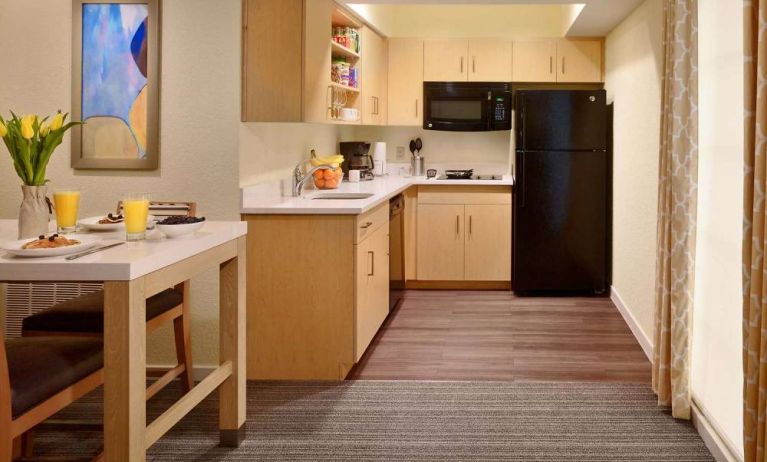 Sonesta ES Suites Atlanta - Perimeter Center North guest room kitchen, featuring fridge-freezer, microwave, hob, and oven.