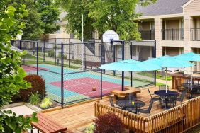 Sonesta ES Suites Atlanta - Perimeter Center North’s terrace is next to the basketball court, and furnished with shaded tables and chairs.