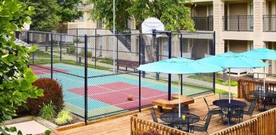 Sonesta ES Suites Atlanta - Perimeter Center North’s terrace is next to the basketball court, and furnished with shaded tables and chairs.