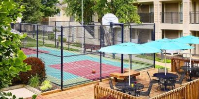 Sonesta ES Suites Atlanta - Perimeter Center North’s terrace is next to the basketball court, and furnished with shaded tables and chairs.