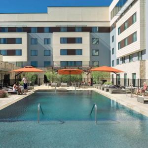 Sonesta Bee Cave Austin’s outdoor pool has sun loungers by the side and shaded seating just a few feet away.