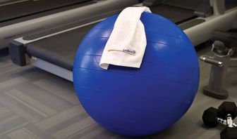 The hotel fitness center has exercise machines including treadmills, alongside equipment such as free weights, gym balls, and benches.