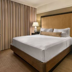 Double bed guest room in Sonesta Suites Scottsdale Gainey Ranch, featuring window, bedside lamps, and television.