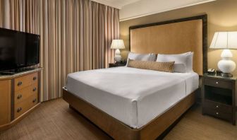 Double bed guest room in Sonesta Suites Scottsdale Gainey Ranch, featuring window, bedside lamps, and television.