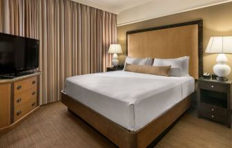 Double bed guest room in Sonesta Suites Scottsdale Gainey Ranch, featuring window, bedside lamps, and television.