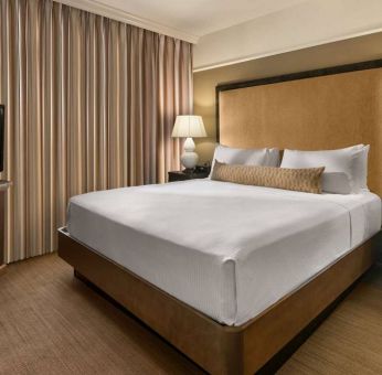 Double bed guest room in Sonesta Suites Scottsdale Gainey Ranch, featuring window, bedside lamps, and television.