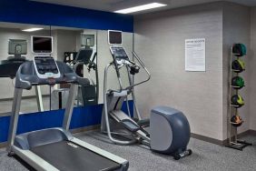 The hotel fitness center is equipped with towels, gym balls, and exercise machines such as an elliptical and a treadmill.