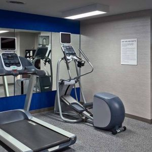 The hotel fitness center is equipped with towels, gym balls, and exercise machines such as an elliptical and a treadmill.