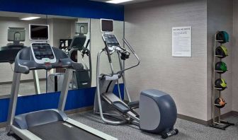 The hotel fitness center is equipped with towels, gym balls, and exercise machines such as an elliptical and a treadmill.