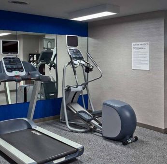 The hotel fitness center is equipped with towels, gym balls, and exercise machines such as an elliptical and a treadmill.