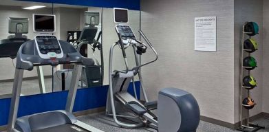 The hotel fitness center is equipped with towels, gym balls, and exercise machines such as an elliptical and a treadmill.