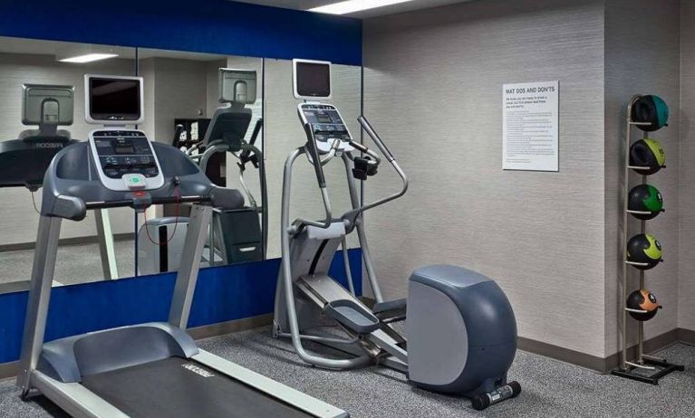 The hotel fitness center is equipped with towels, gym balls, and exercise machines such as an elliptical and a treadmill.