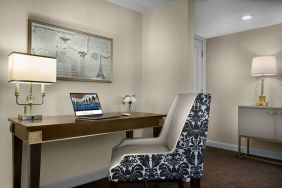 The Chase Park Plaza Royal Sonesta St. Louis guest room workspace, furnished with desk, chair, and lamp.