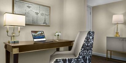 The Chase Park Plaza Royal Sonesta St. Louis guest room workspace, furnished with desk, chair, and lamp.