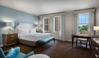 The Chase Park Plaza Royal Sonesta St. Louis double bed guest room, including armchair, workspace desk and chair, and windows.