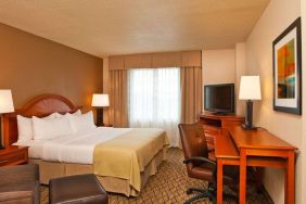 Double bed guest room in Sonesta Atlanta Airport South, featuring TV, window, and workspace desk and chair.