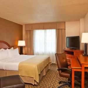 Double bed guest room in Sonesta Atlanta Airport South, featuring TV, window, and workspace desk and chair.