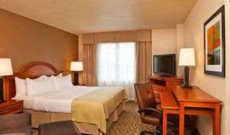 Double bed guest room in Sonesta Atlanta Airport South, featuring TV, window, and workspace desk and chair.