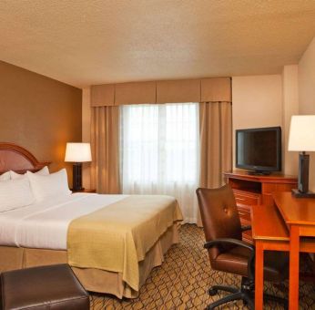 Double bed guest room in Sonesta Atlanta Airport South, featuring TV, window, and workspace desk and chair.